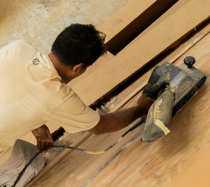 Arania craftsman sanding a custom timber panel