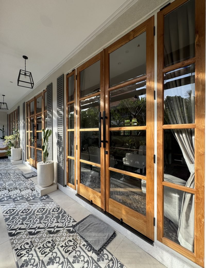Villa terrace lined with custom teak glass doors and shutters